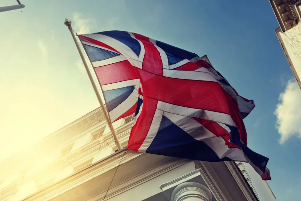 Union Jack Waving Proudly Above Building, Blue Sky