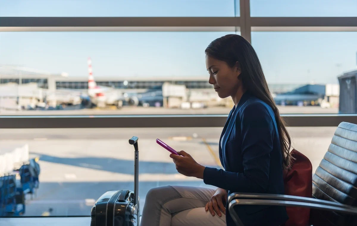 businesswoman checking her phone in an airport.